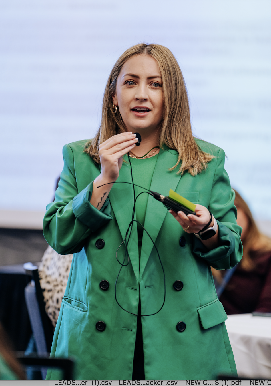 Diana speaking on a panel in a green blazer